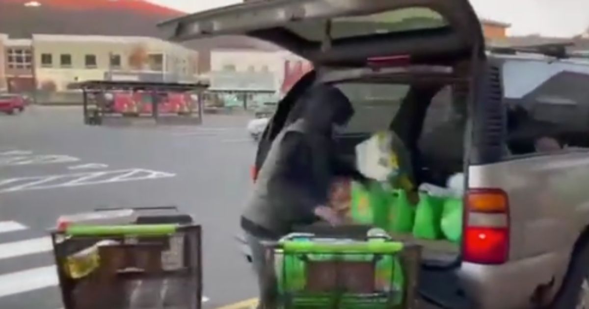 A man is seen in Oxford, Connecticut, loading up a vehicle with two carts full of goods that he did not pay for on Wednesday.