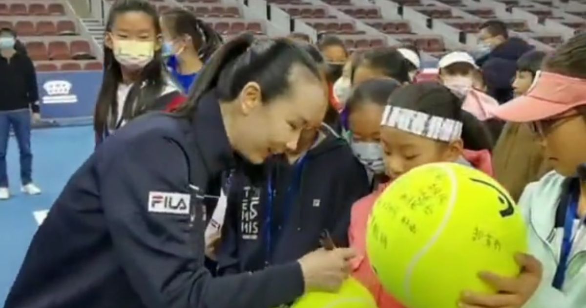A video released from the Chinese government, allegedly shows tennis star Peng Shuai, left, signing tennis balls at the opening ceremony of a tennis match final for teenagers in Beijing on Sunday.