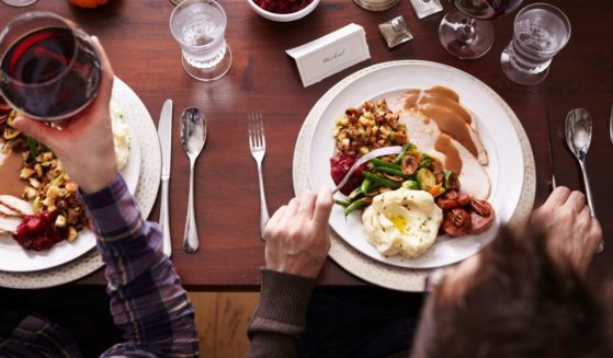 This stock image shows two people eating Thanksgiving dinner. A new tactic being used may discourage even more people from celebrating Thanksgiving.