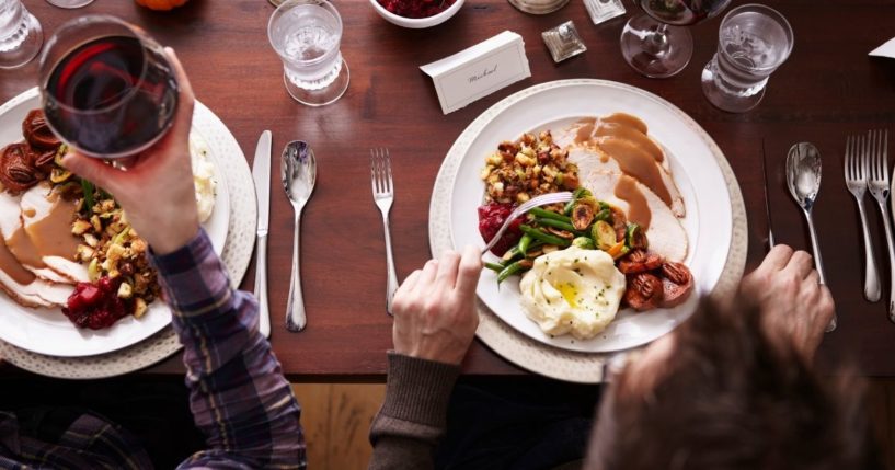 This stock image shows two people eating Thanksgiving dinner. A new tactic being used may discourage even more people from celebrating Thanksgiving.