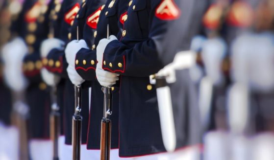 United States Marines stand in their Dress Blues during a ceremony.