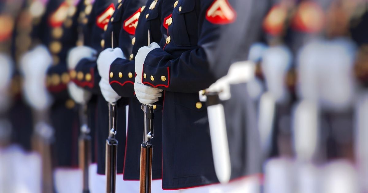 United States Marines stand in their Dress Blues during a ceremony.