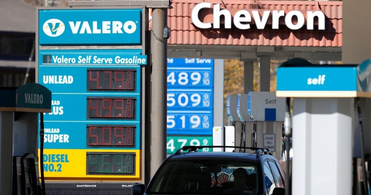 Gas prices around $5 per gallon are displayed at Valero and Chevron stations in Mill Valley, California, on Oct. 12.