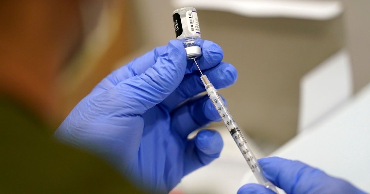 A health care worker handles a syringe with the Pfizer COVID-19 vaccine at Jackson Memorial Hospital in Miami, on Oct. 5.