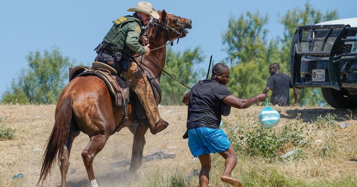 A U.S. Border Patrol agent on horseback tries to stop a Haitian migrant near the Acuna Del Rio International Bridge in Del Rio, Texas, on Sept. 19.