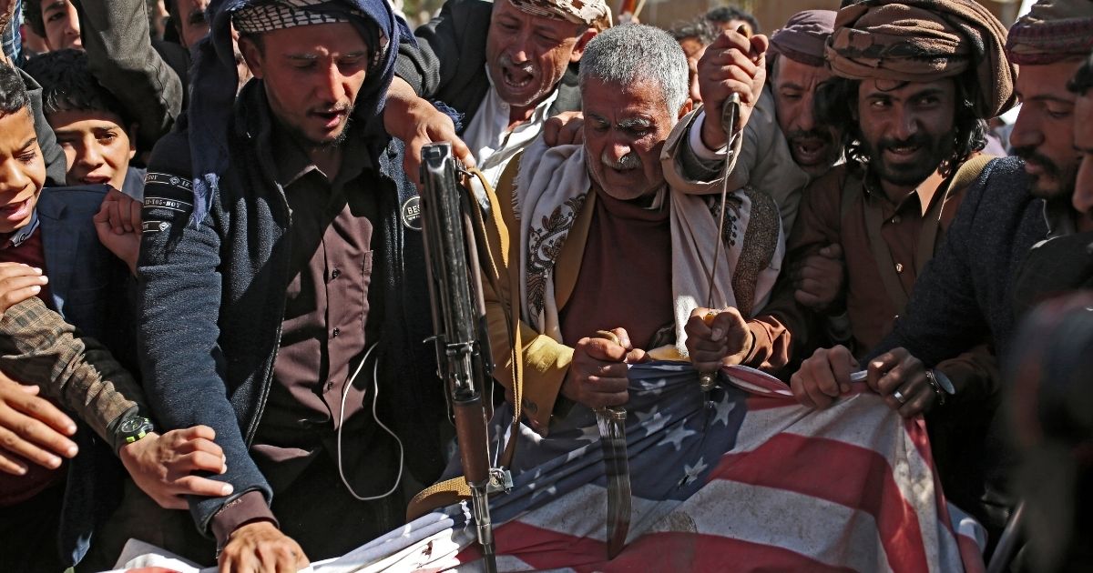 Supporters of Yemen's Houthi terrorist group desecrate a representation of an American flag during a demonstration outside the shuttered U.S. Embassy in Sanaa, Yemen, in January.