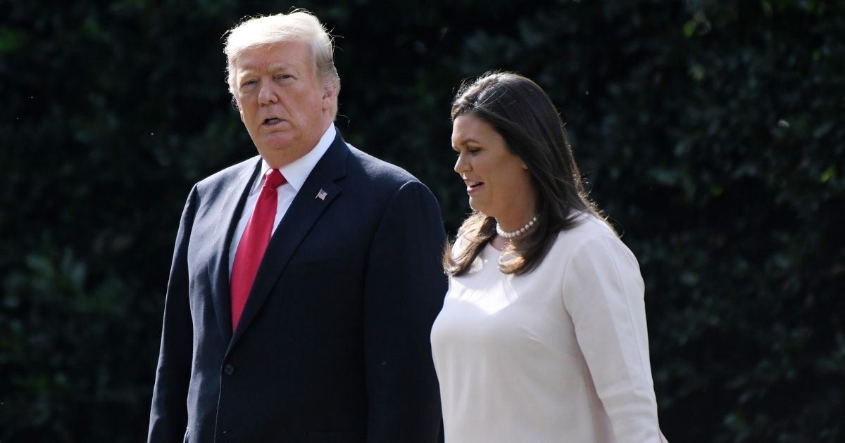 Then-President Donald Trump and White House press secretary Sarah Huckabee are pictured in a file photo from 2018 outside the White House.