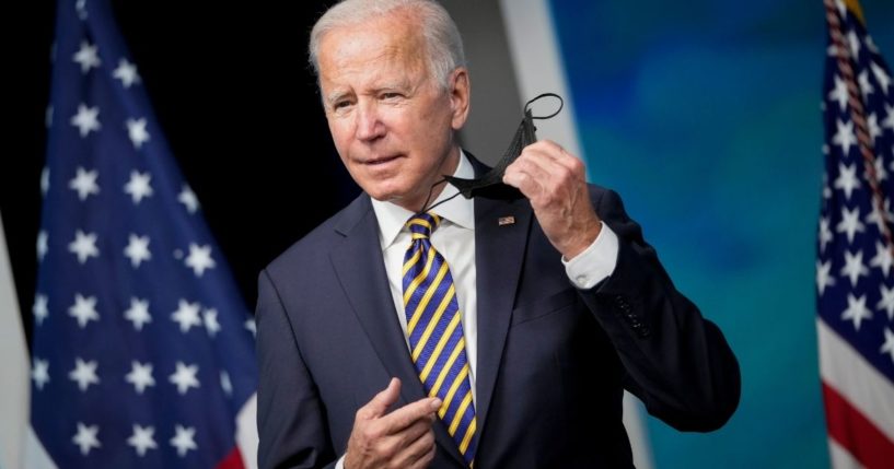 President Joe Biden removes his face mask as he prepares to speak at the White House on Oct. 14, 2021, about the coronavirus pandemic and to encourage states and businesses to support vaccine mandates.
