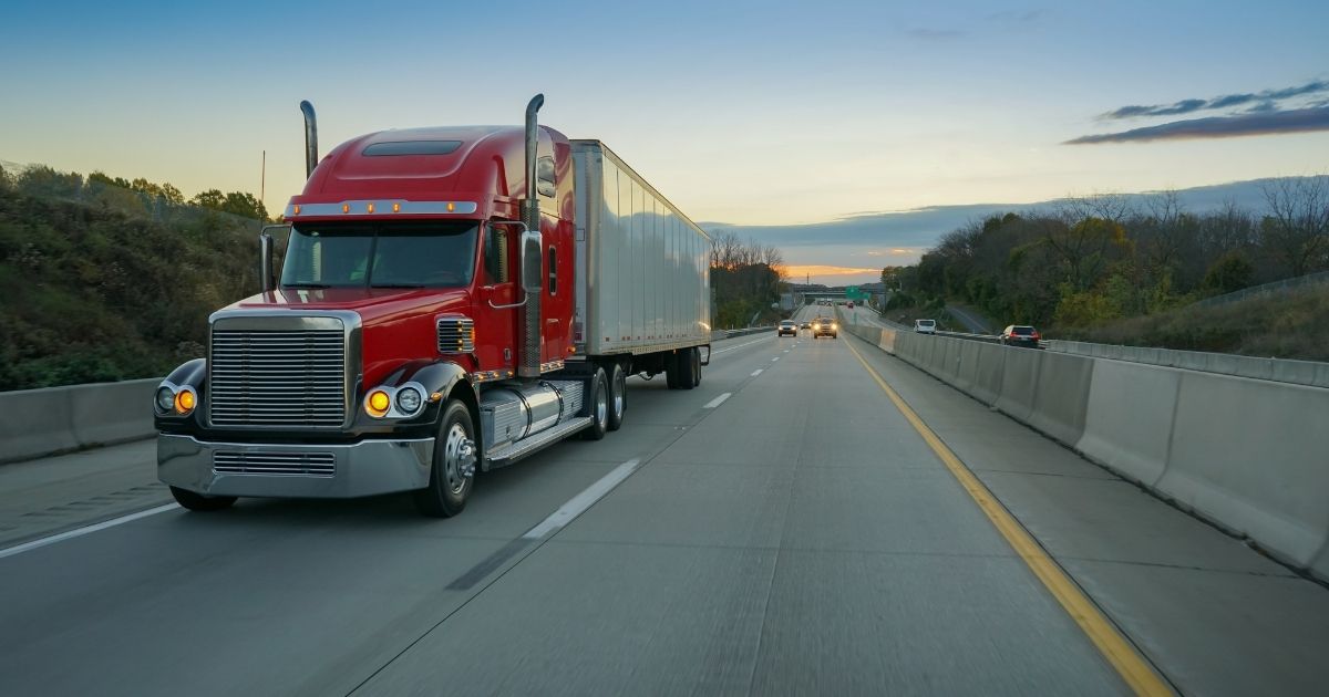 A semi-truck is seen on a highway in the above stock image.