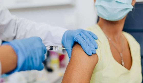A woman receives a vaccine in the above stock image.