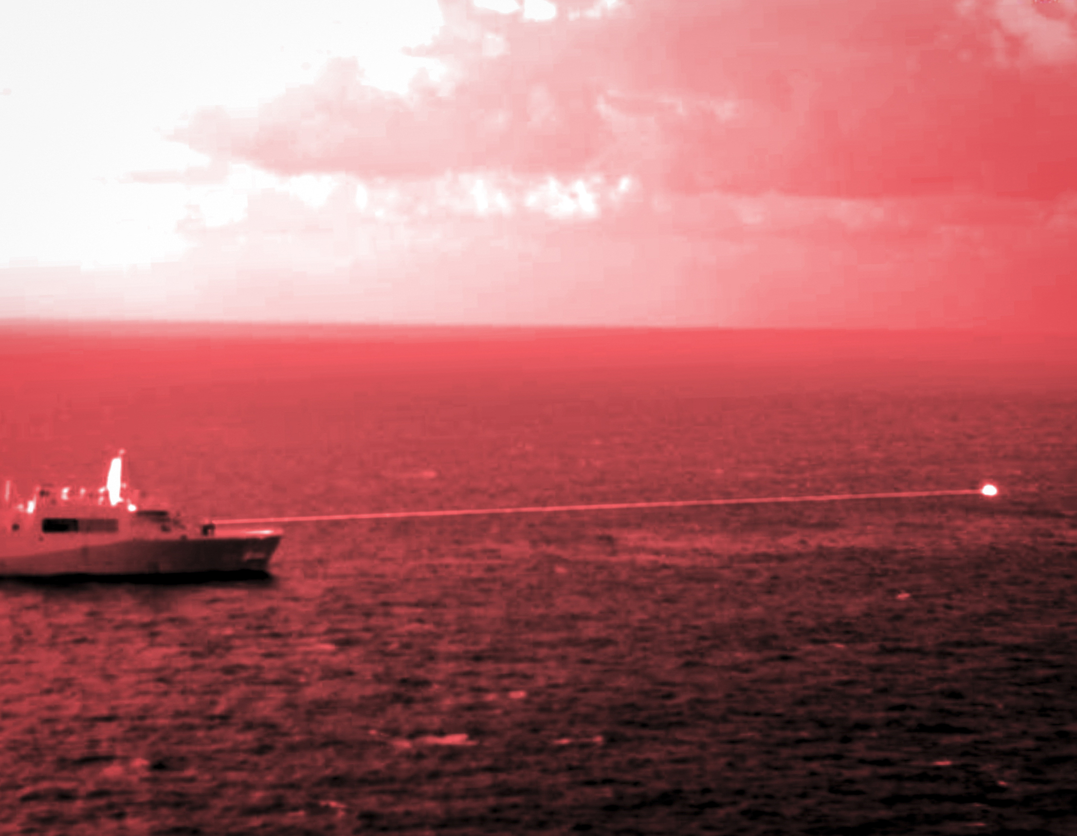 In this handout infrared photo from the U.S. Marine Corps, the USS Portland fires a laser weapon system at a target floating in the Gulf of Aden on Tuesday. The U.S. Navy announced Wednesday that it tested a laser weapon and destroyed a floating target in the Middle East.