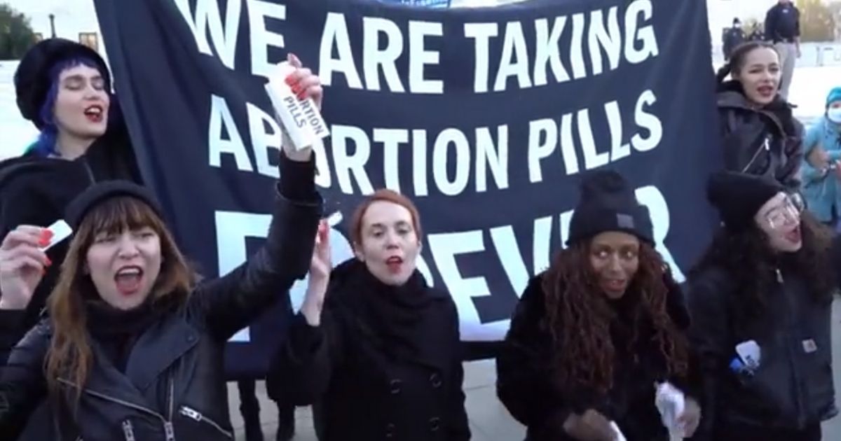 Women protesting outside the U.S. Supreme Court say they're taking abortion pills.