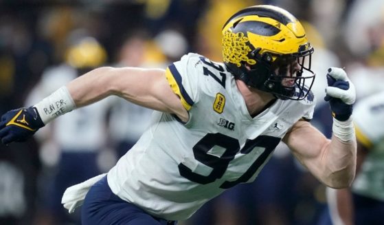 Michigan defense end Aidan Hutchinson gets ready to rush during a play in the Big Ten Championship game on Sat. Hutchinson and the rest of the team wore "TM 42" patches and Hutchinson wrote "Play for Tate" on his wrist tape to honor one victim, Tate Myre, of the Oxford High School shooting.