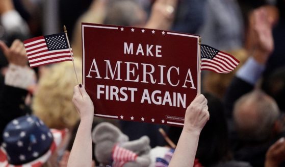 A delegate holds up a "Make America First Again" sign during the opening of the third day of the Republican National Convention at the Quicken Loans Arena in Cleveland on July 20, 2016.