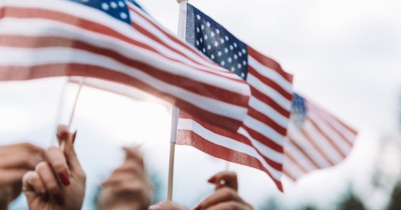 People wave the American flag in this stock image.