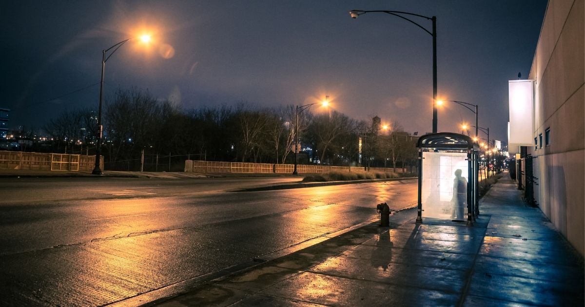 This stock image shows a person waiting at a bus stop at night. In North Philadelphia on Monday, a 14-year-old was shot almost 20 times while waiting for a bus.