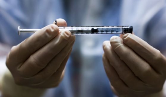A pharmacy technician holds a dose of the Johnson & Johnson COVID-19 vaccine on Dec. 15, 2020, in Aurora, Colorado.
