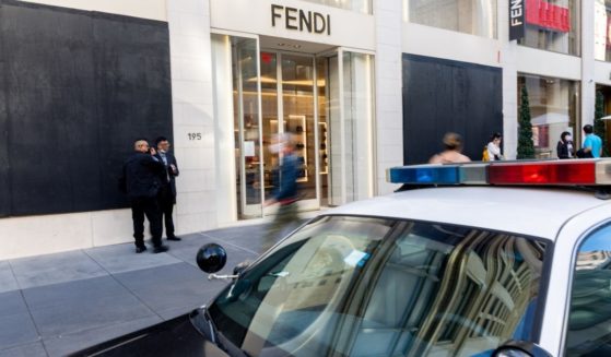 Pedestrians walk past a Fendi store with boarded-up windows on Nov. 30 in San Francisco.
