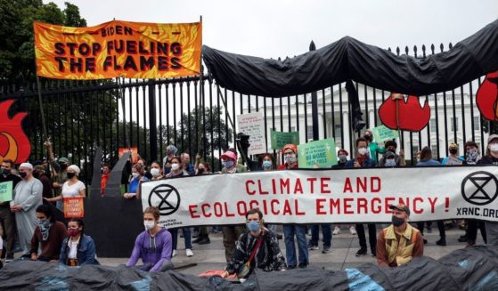 Climate protesters demonstrate in front of the White House in Washington on Oct. 12 to demand that President Joe Biden do more to curb climate change and ban fossil fuels.