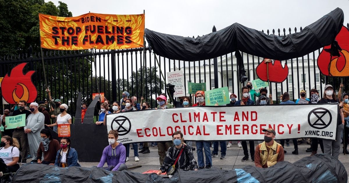 Climate protesters demonstrate in front of the White House in Washington on Oct. 12 to demand that President Joe Biden do more to curb climate change and ban fossil fuels.