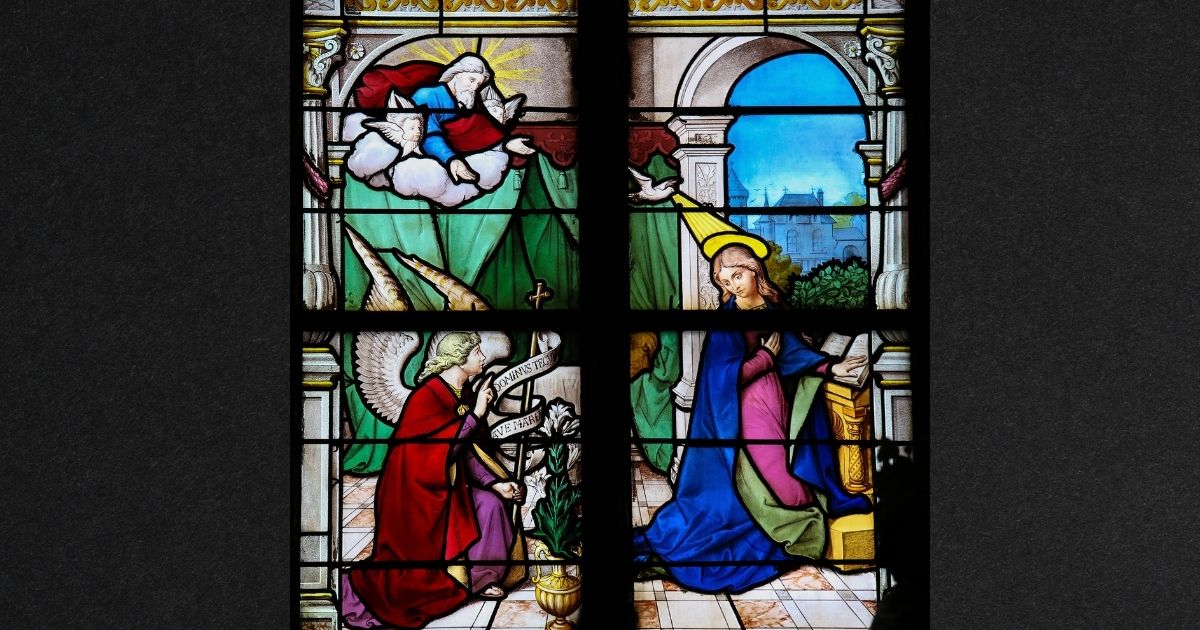 The Annunciation is depicted in a stained-glass window in Saint Catherines church in Honfleur, Calvados, France. An author who claims God is a black woman recently made a controversial claim about the Immaculate Conception.