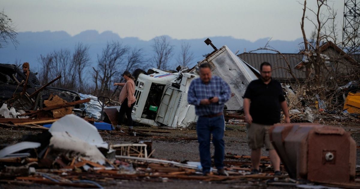 Residents walk through wreckage on Saturday after a tornado hit Mayfield, Kentucky.