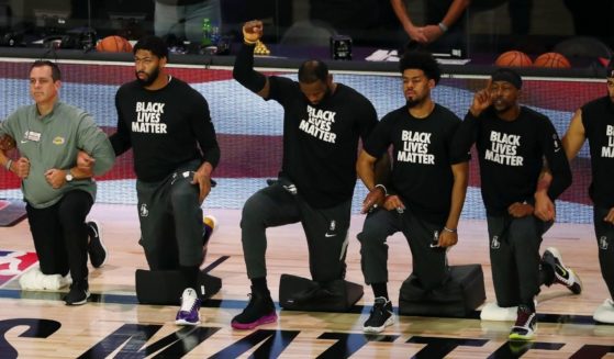 LeBron James and other members of the Los Angeles Lakers wear "Black Lives Matter" shirts and kneel during the national anthem before a game against the Indiana Pacers at the ESPN Wide World Of Sports Complex in Lake Buena Vista, Florida, on Aug. 8, 2020.