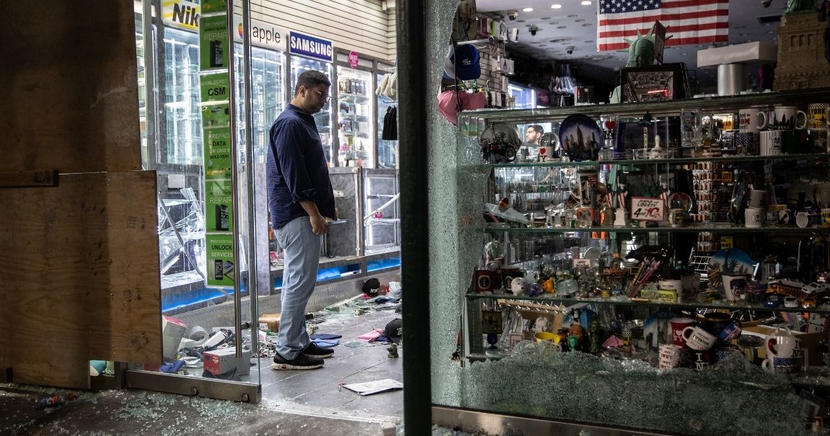 A shop owner looks over damage in a looted souvenir shop near Times Square after a night of protests and vandalism over the death of George Floyd early on June 2, 2020, in New York City.