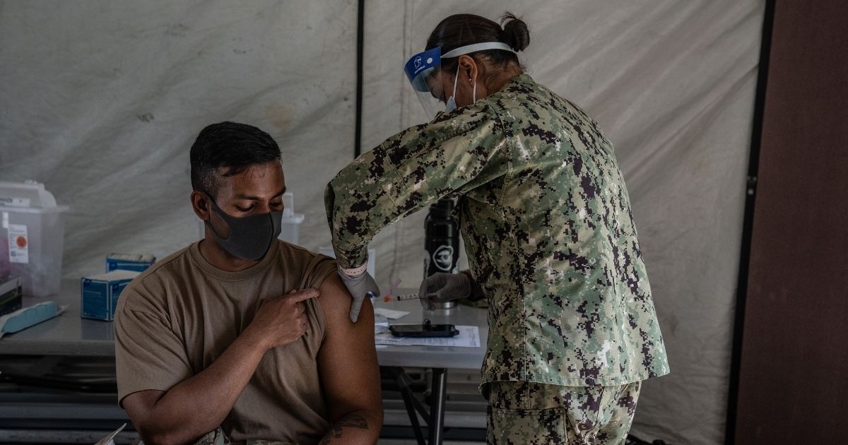 A member of the United States Marines receives a Moderna coronavirus vaccine at Camp Foster in Ginowan, Japan, in this file photo from April 2021. Several sources have anonymously said the US is apparently denying all vaccine waiver requests and is discharging Marines in a merciless fashion, doing as much harm to them as possible on their way out. One officer called it 'a political purge, taking out some of the best and brightest' in all branches of the US military.