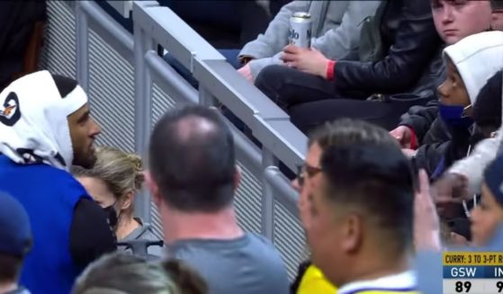 Golden State Warriors guard Gary Payton II speaks to a fan after replacing the drink he spilled.