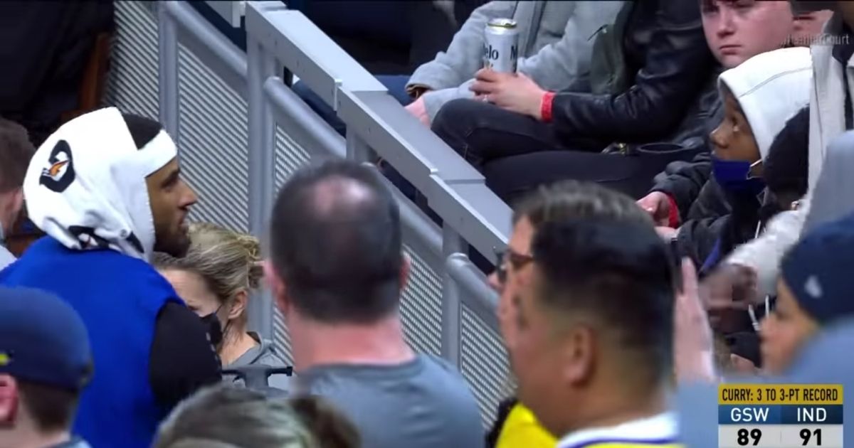 Golden State Warriors guard Gary Payton II speaks to a fan after replacing the drink he spilled.