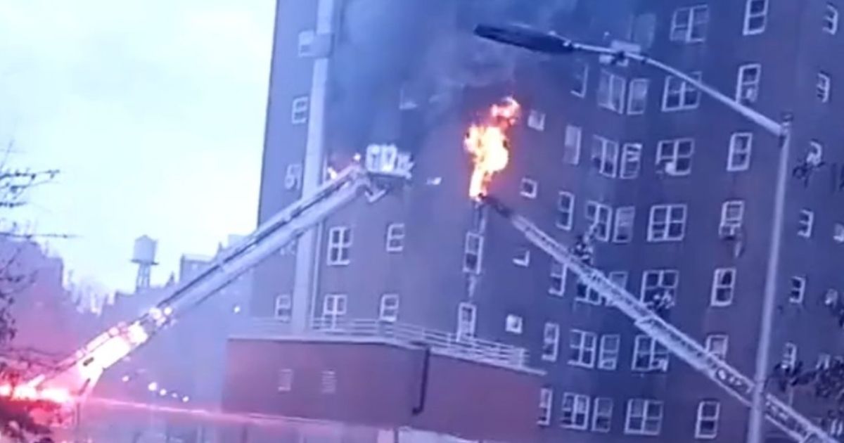 A fire is seen emerging from the fourth story of the New York City Housing Authority’s Jacob Riis Houses on Thursday morning.