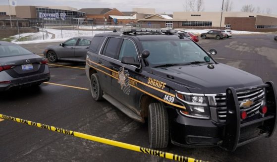 The parking lot of Oxford High School in Oxford, Michigan, is secured by an Oakland County Sheriff's deputy on Dec. 1, after a 15-year-old student brought a gun to school, killing 4 and injuring 7 others.