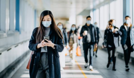 This stock image shows a group of people walking with masks on. A study in the possession of the United Kingdom Health Security Agency has reportedly found that the omicron variant will give individuals a more mild case of COVID-19 than delta.