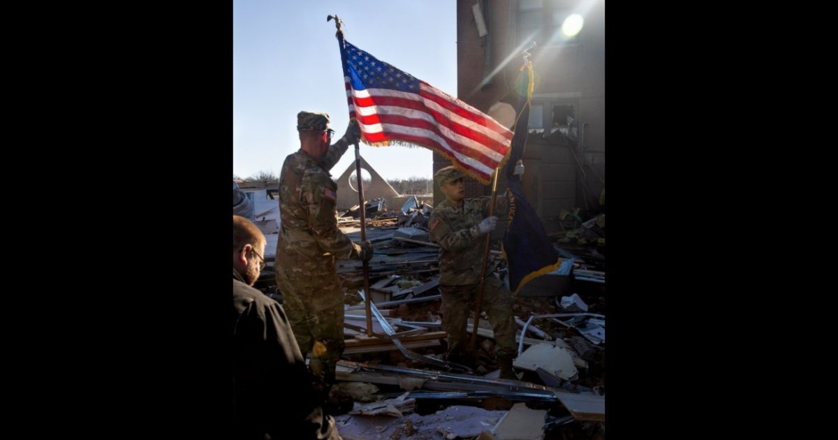 Troops with the Kentucky National Guard rummage through piles of debris after tornadoes destroyed several homes and structures, and killed 64 people over the weekend.