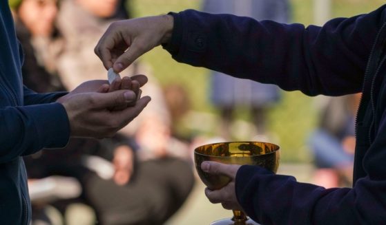 A priest serves communion in a file photo from March 2020. A Michigan diocese has attracted criticism for advising transgender individuals that they must repent in order to participate in sacraments.