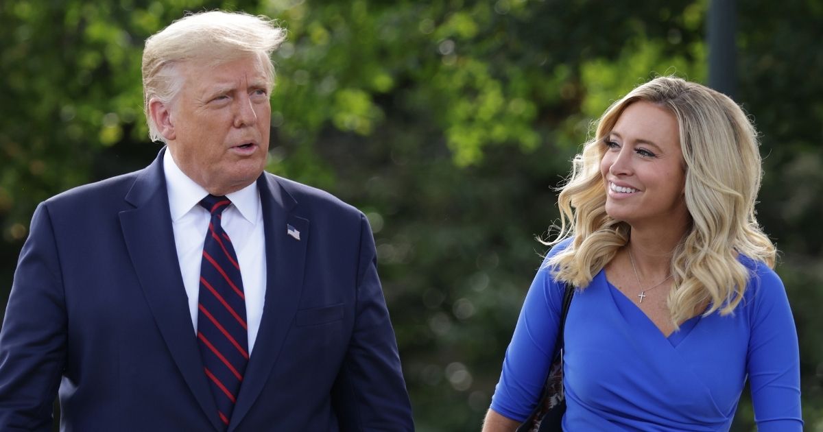 Then-President Donald Trump walks with his press secretary, Kayleigh McEnany, toward members of the media prior to Trump’s departure from the White House for a trip to Philadelphia on Sept. 15, 2020.