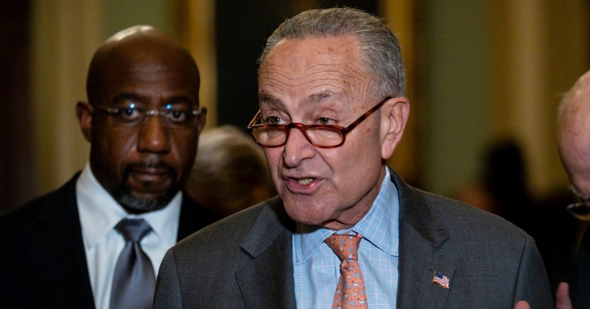Senate Majority Leader Chuck Schumer addresses reporters after a Democratic caucus luncheon at the Capitol on Nov. 2 with Georgia Sen. Raphael Warnock, left.