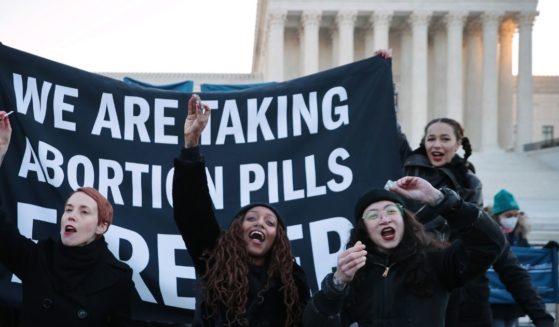 Protesters prepare to take abortion pills while demonstrating in front of the U.S. Supreme Court on Dec. 1 in Washington, D.C.