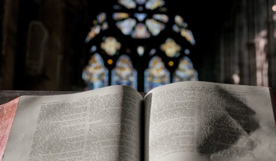 A Bible lies open on a pulpit in the above stock image.