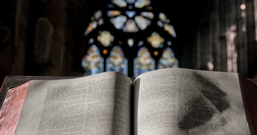 A Bible lies open on a pulpit in the above stock image.