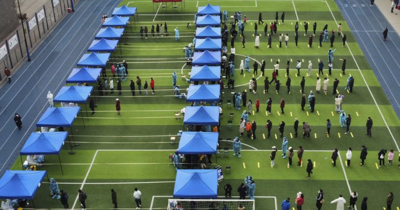 Residents line up on a football field for a COVID test during a mass testing in north China's Tianjin municipality on Sunday.