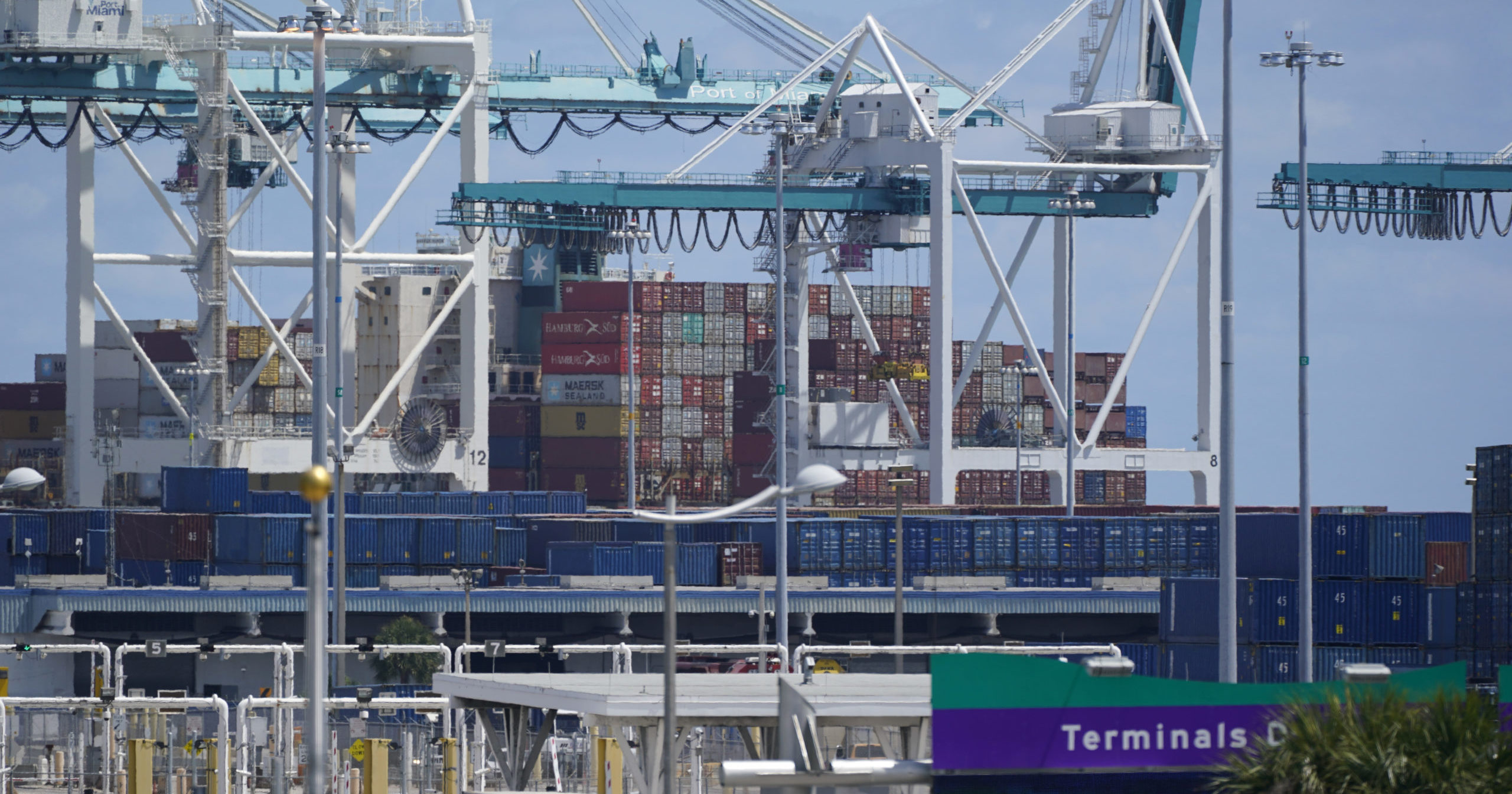 Cargo containers are seen stacked near cranes at Port Miami in Miami on April 9, 2021.