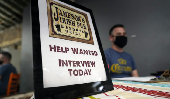 A hiring sign is shown at a booth for Jameson's Irish Pub during a job fair on Sept. 22, 2021, in the West Hollywood section of Los Angeles, California.