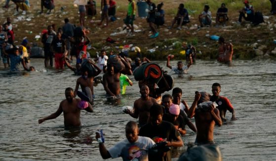 Migrants, many from Haiti, wade across the Rio Grande from Del Rio, Texas, to return to Ciudad Acuna, Mexico, on Sept. 21, 2021.