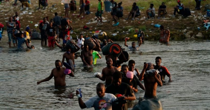 Migrants, many from Haiti, wade across the Rio Grande from Del Rio, Texas, to return to Ciudad Acuna, Mexico, on Sept. 21, 2021.