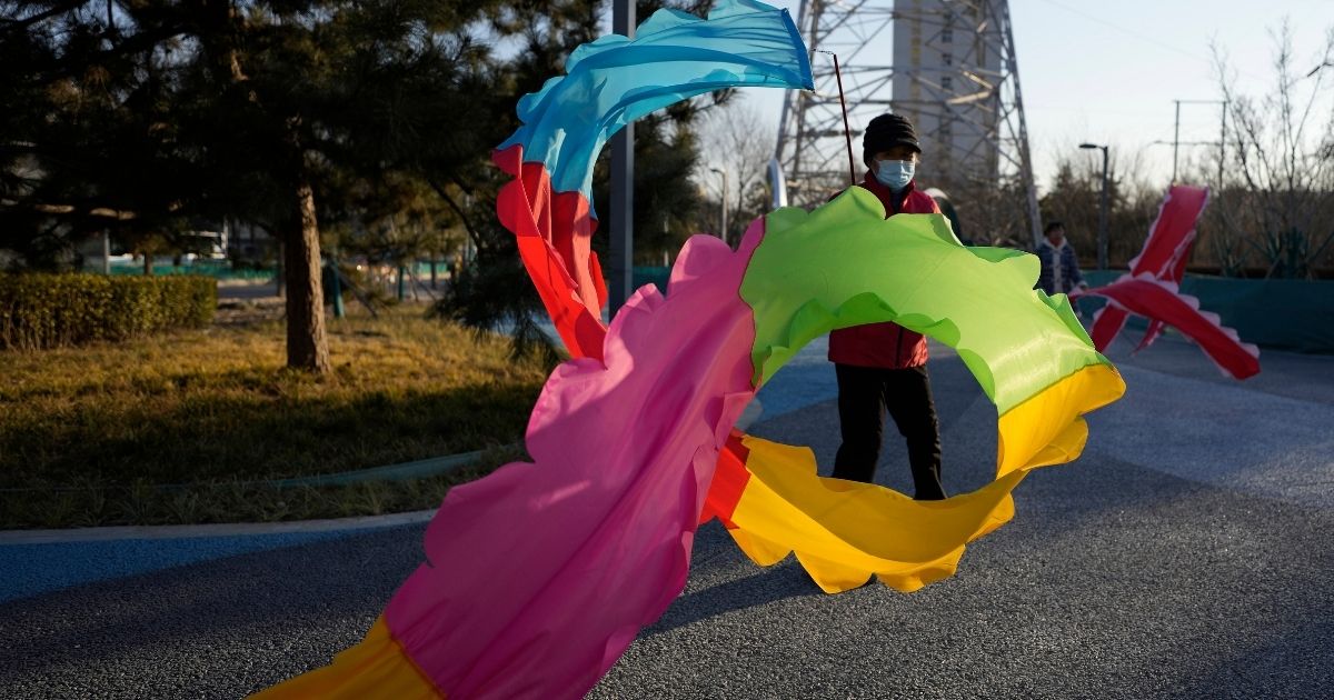 A resident wearing a mask exercises with a colored ribbon in Beijing, China, Tuesday, Jan. 11. The Chinese capital is on high alert ahead of the Winter Olympics as China locks down a third city elsewhere for COVID-19 outbreak. 