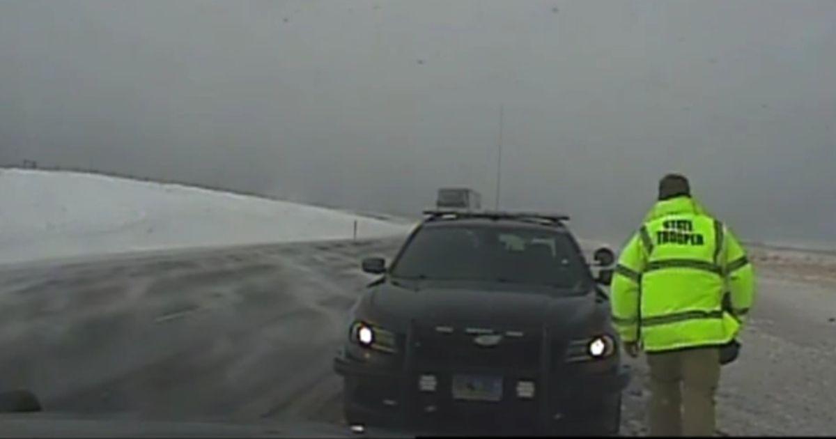 A Wyoming state trooper helping with a crash approaches his vehicle before quickly realizing an SUV is barreling toward him.