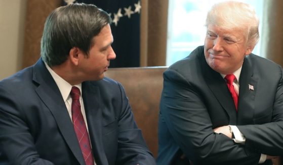 Ron DeSantis , who was then Governor-elect of Florida, sits next to then-President Donald Trump at the White House in this file photo from December 2018. Trump has denied feuding with DeSantis, in spite of mainstream media accounts to the contrary.