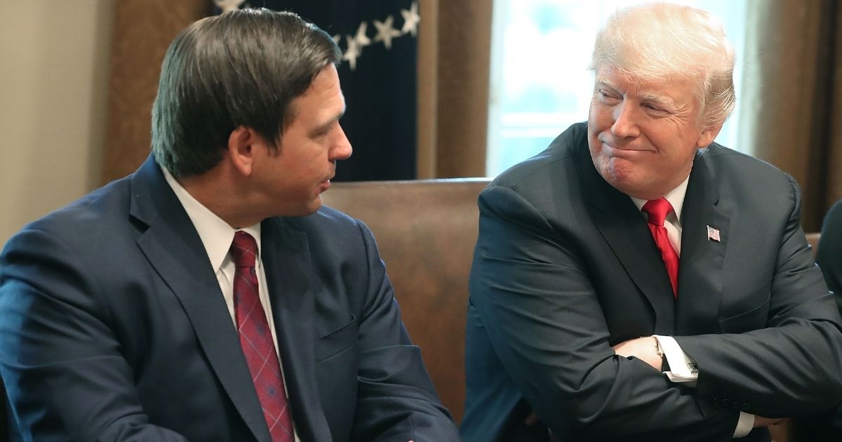 Ron DeSantis , who was then Governor-elect of Florida, sits next to then-President Donald Trump at the White House in this file photo from December 2018. Trump has denied feuding with DeSantis, in spite of mainstream media accounts to the contrary.
